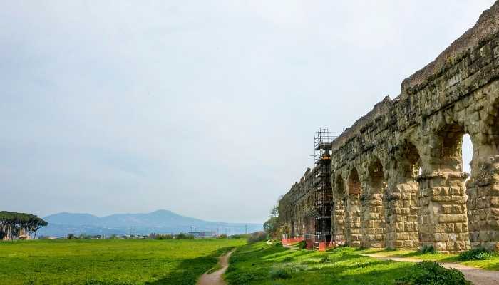 Imagem de aqueduto se perde no horizonte e com campos verde a frente