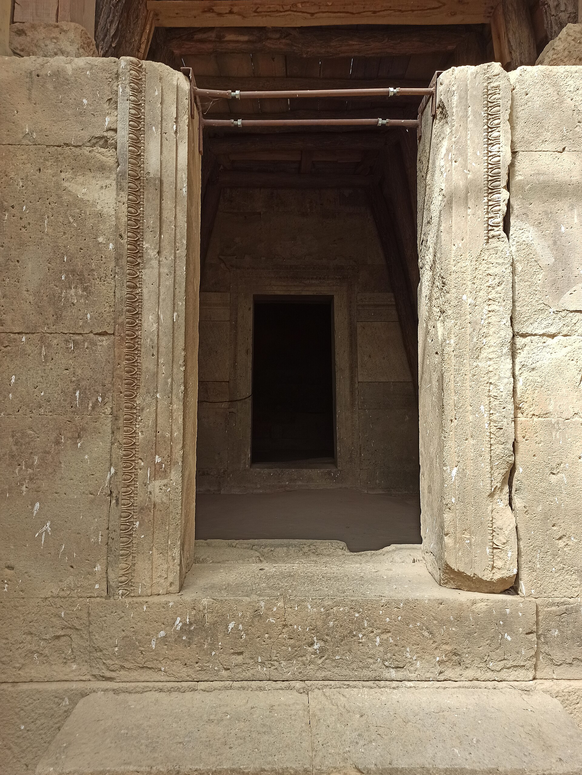 Entrada de pedra de um túmulo antigo com batentes entalhados e uma câmara escura ao fundo, no Templo de Culto Trácio perto de Starosel