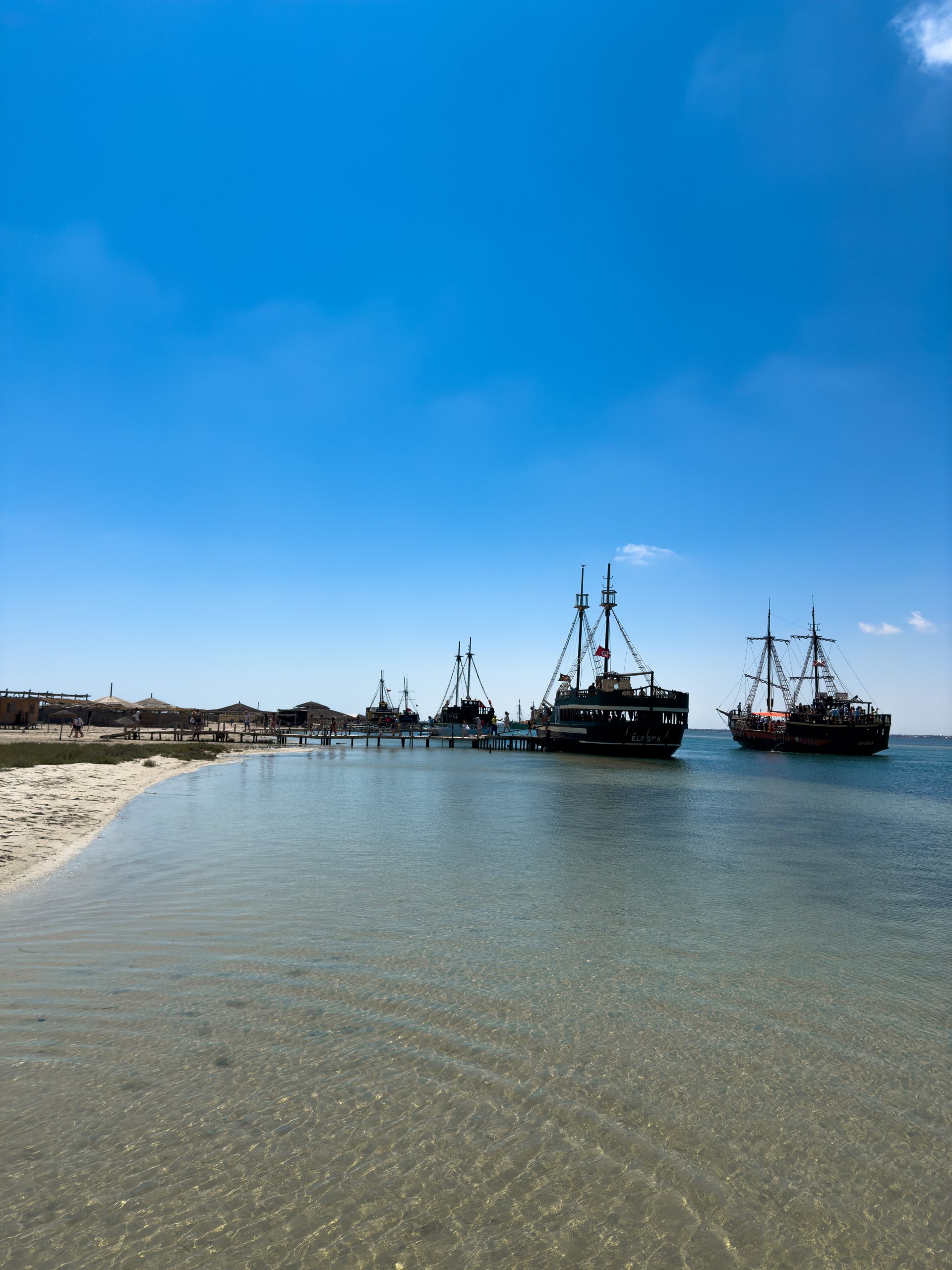 Barcos piratas ancorados na água rasa da península de Ras R'mel, a Ilha dos Flamingos, em Djerba