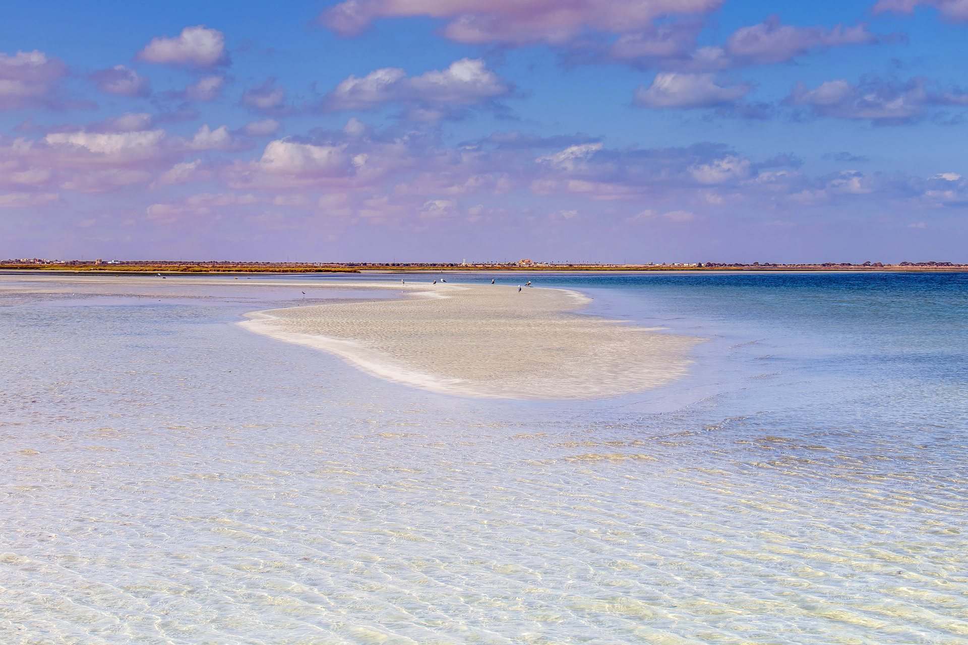 Praia de Hessi Jerbi, em Zarzis, com areia clara e água rasa azul-turquesa