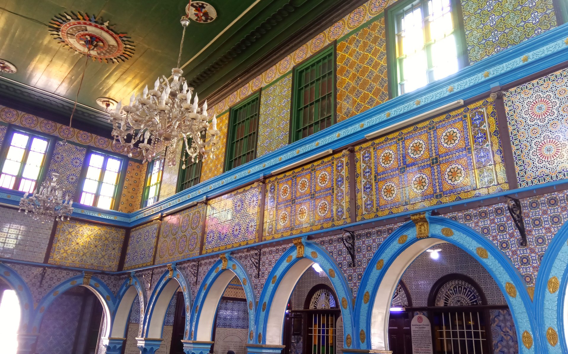 Interior da sinagoga de El Ghriba, em Djerba, com arcos azuis, azulejos e lustres